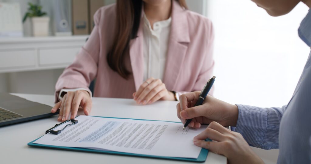Close-up hand asia people woman fill rent loan form write legal debt letter at lawyer